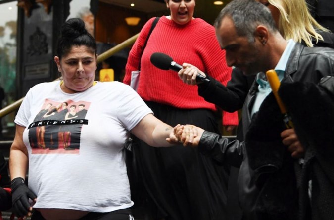 Alison Mains (left) is helped by a friend as she leaves the Downing Centre District Court in Sydney, Wednesday, September 18, 2019.